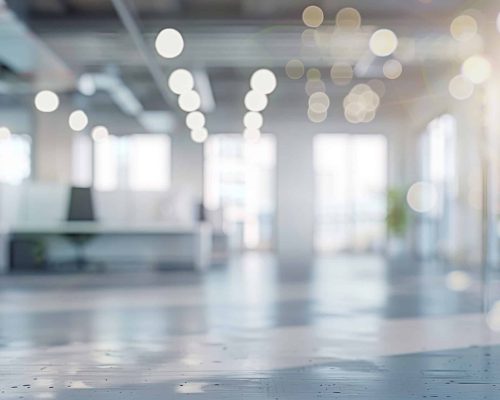 A blurred view of an empty office building, showcasing the haunting stillness and solitude within, Blurred empty open space office. Abstract light bokeh at office interior background for design.